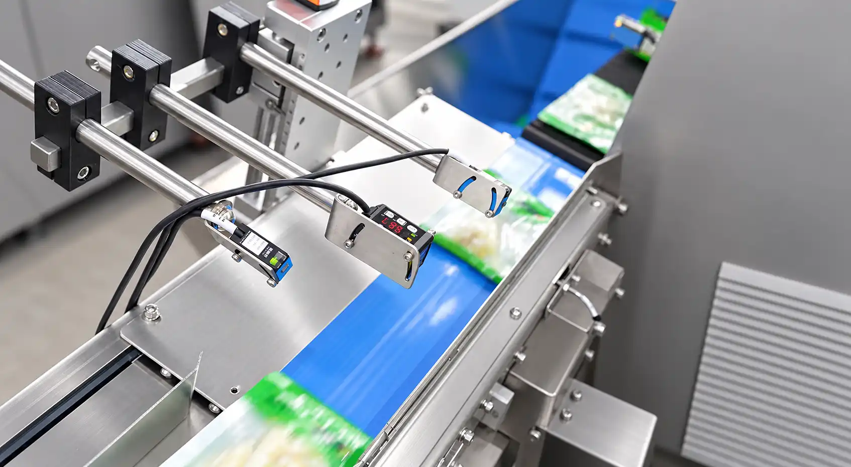 Differential-speed conveyor with photoelectric sensors for package spacing and detection